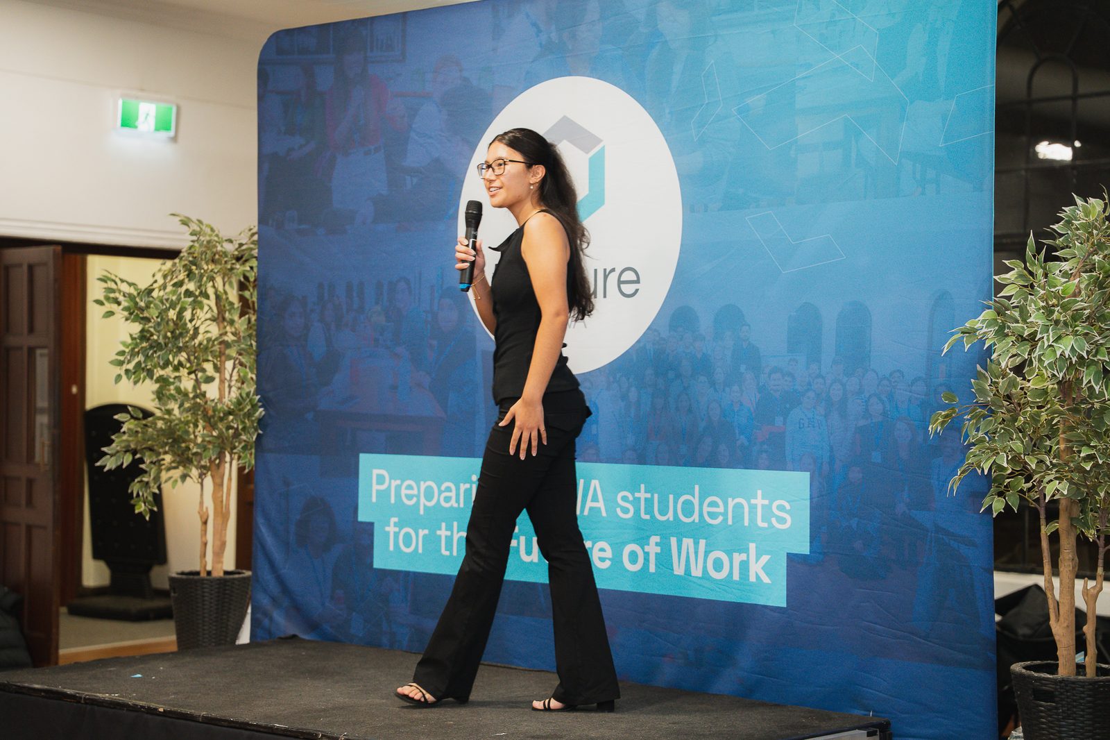 Taleena speaking on stage at a student event